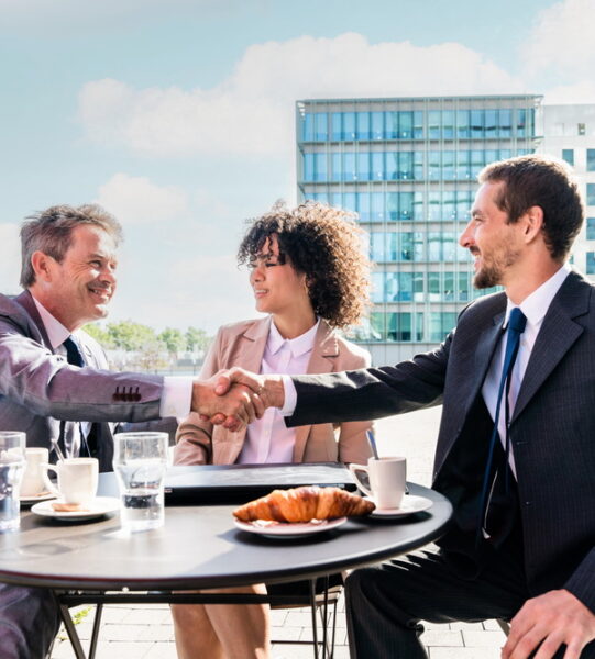 Senior businessman, caucasian man and beautiful hispanic businesswoman meeting in a bar restaurant  - Three colleagues bonding in a cafe after work