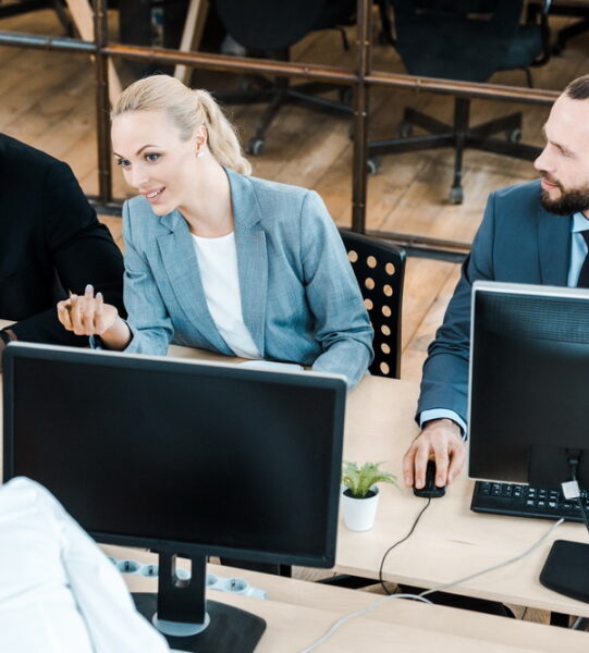 attractive businesswoman gesturing and talking with multicultural coworkers
