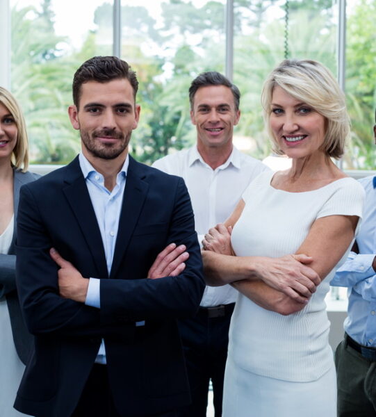 Business executives with arms crossed at conference center