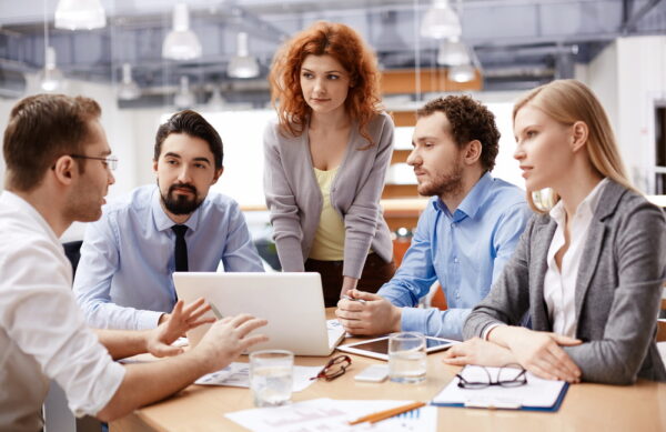 Group of business partners listening to colleague at meeting